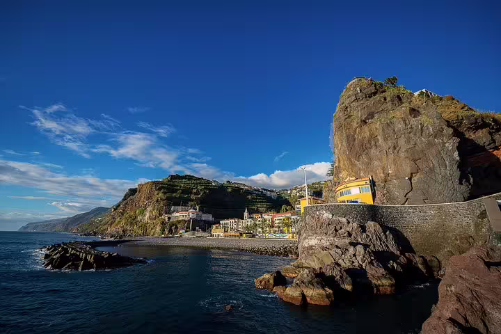 Dramatic coastal cliffs and charming village in Madeira, perfect for scenic West Tour exploration.