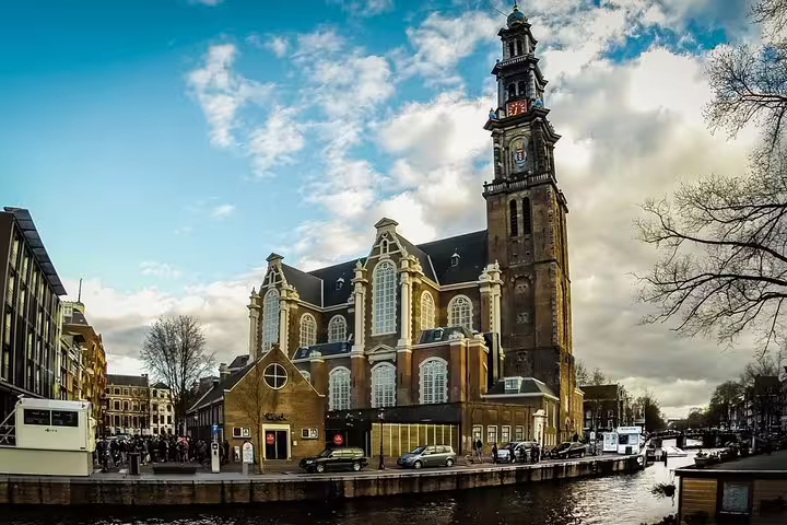 Westerkerk church by Amsterdam canal, a landmark stop on a self-guided e-scavenger hunt city tour