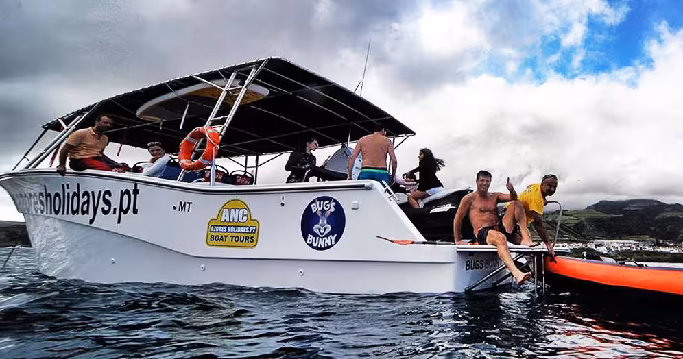 Small boat cruise for half-day whale and dolphin watching, guests boarding near the Azores coastline