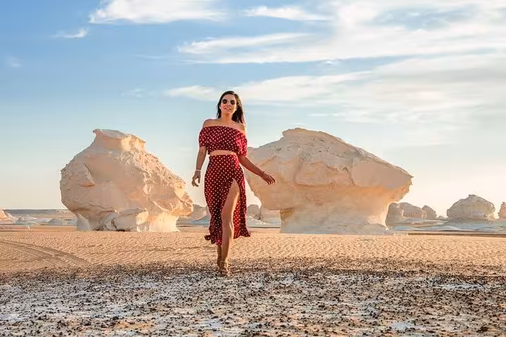 Traveler walking among White Desert chalk formations on a 3-day eco Bahariya Oasis camping tour in Egypt