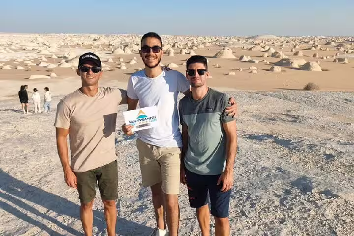 Friends pose in Egypt’s White Desert with chalk rock formations on a private 4-day Bahariya Oasis tour