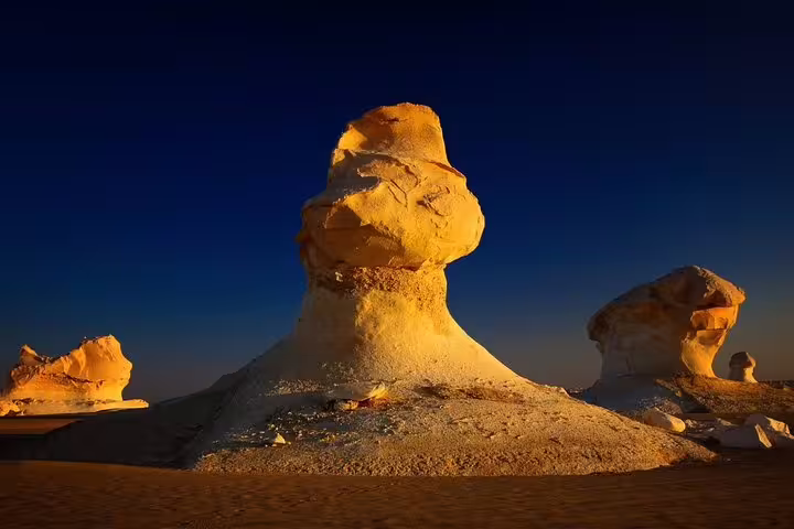 Golden-lit chalk monoliths in Egypt White Desert, Bahariya, featured on 7 days 6 nights Siwa tour package