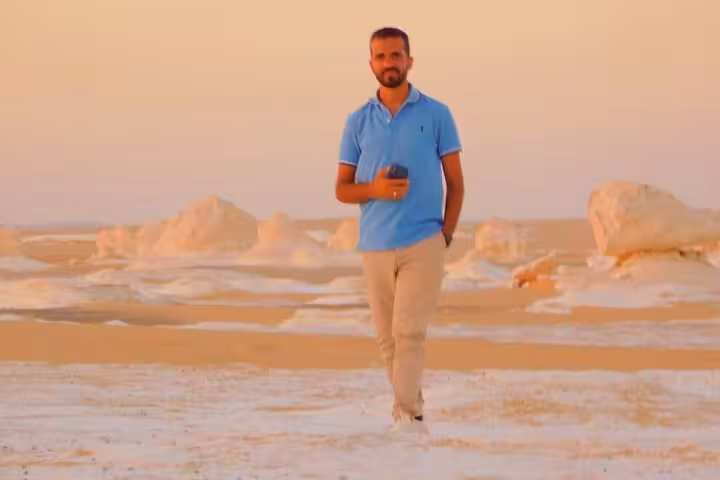 Traveler walking among White Desert chalk formations on private 2-day Black and White Desert camping tour