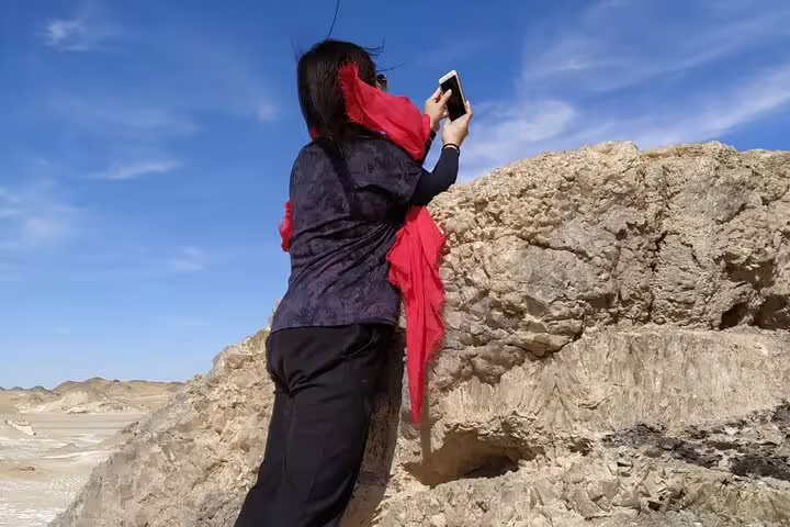 Traveler photographing chalk rock formations in Egypt’s White Desert on a private day tour from Bahariya Oasis