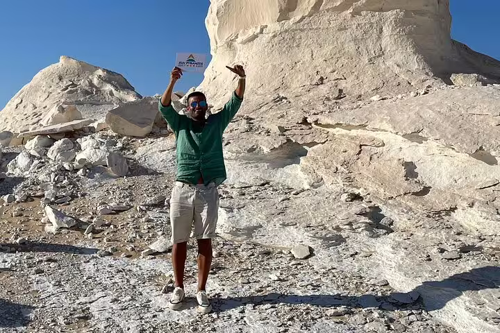Traveler posing by White Desert chalk cliffs on a private 2-day Jeep safari from Bahariya Oasis, Egypt
