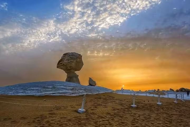 Sunset view of unique mushroom-shaped rock formations in the White Desert, highlighting the serene beauty of Egypt's landscapes.