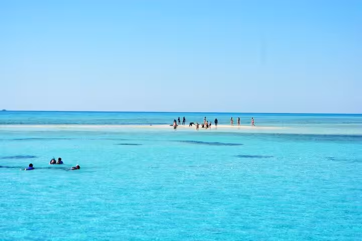 Visitors on White Island sandbar with turquoise Red Sea views during Sharm El Sheikh Ras Mohamed day sail
