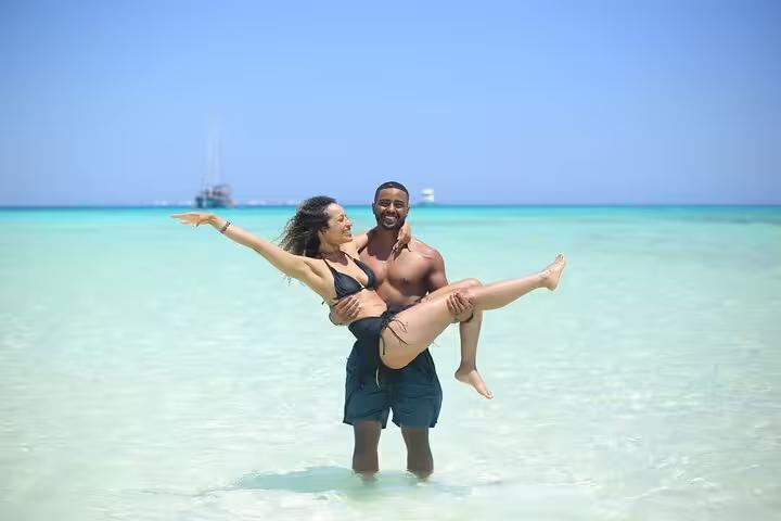 Couple enjoying shallow turquoise lagoon at White Island on Sharm El Sheikh day sail to Ras Mohamed National Park