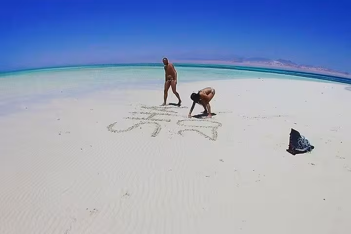 Travelers on White Island sandbar in Ras Mohamed, Red Sea, during VIP boat snorkeling and diving day trip