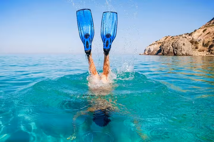 Snorkeler with fins in crystal-clear Red Sea water on White Island trip from Sharm El Sheikh, Egypt
