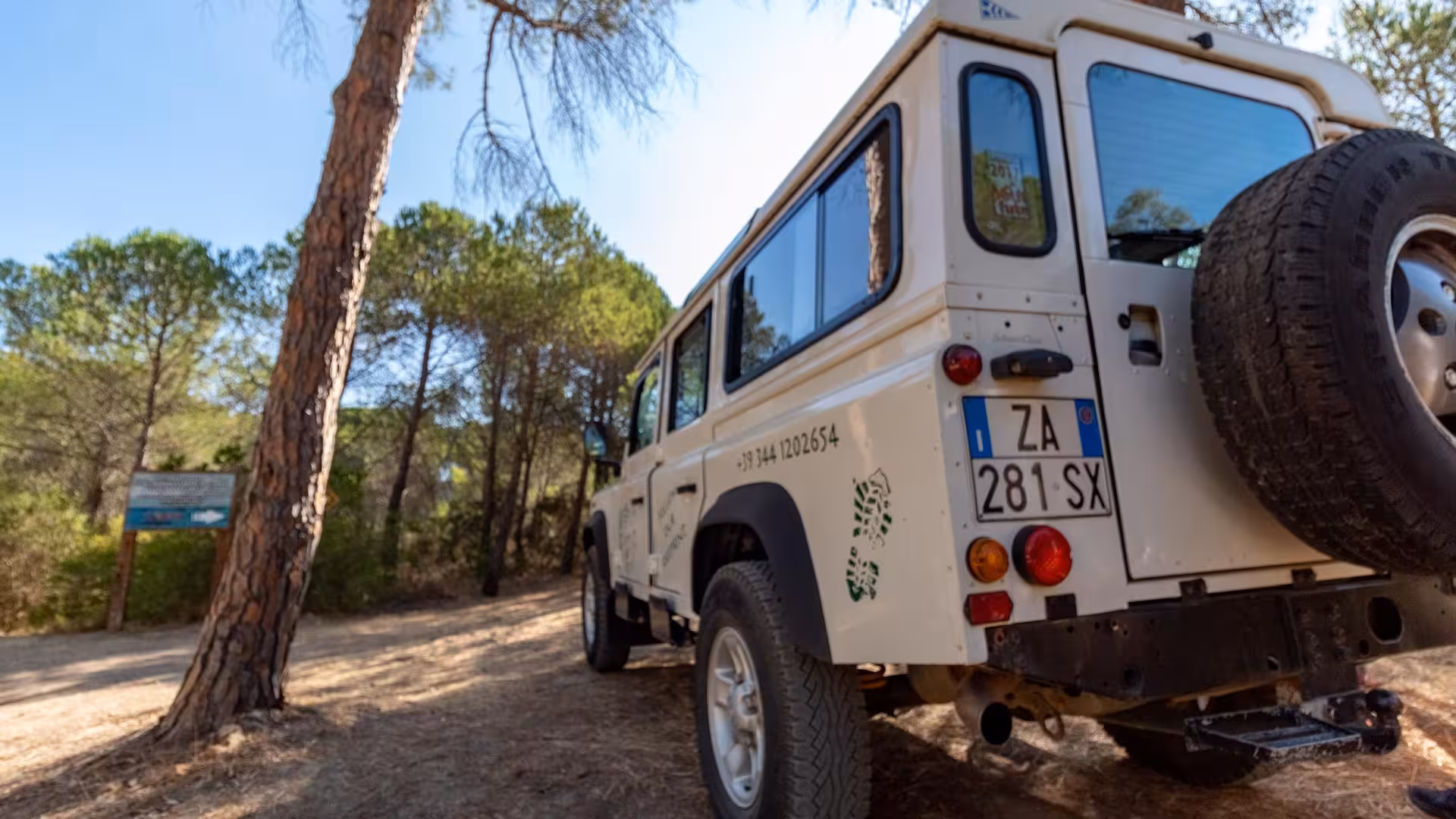 White Jeep parked in a lush forest setting on the Biderosa and Capo Comino private tour from Orosei.