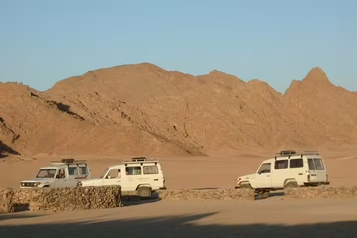 White 4x4 jeeps parked near desert hills in Marsa Alam on jeep safari tour with dinner and evening show