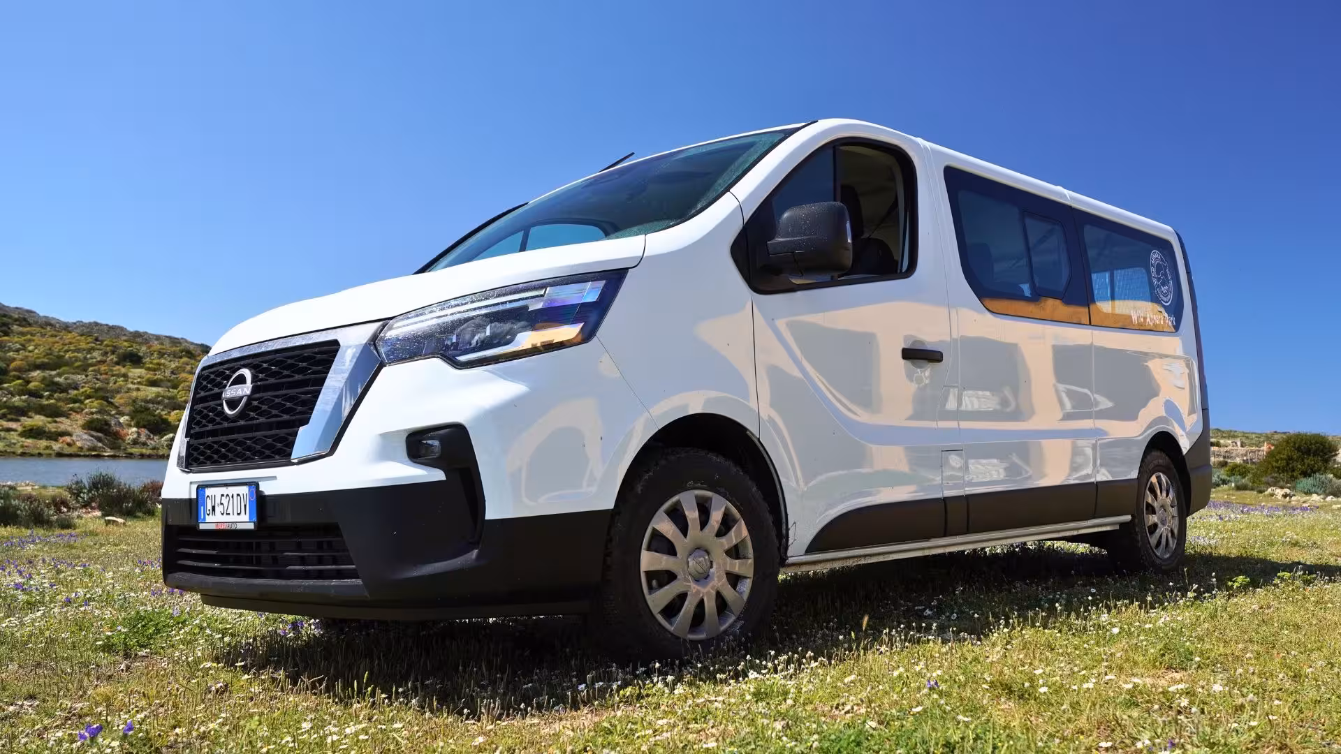 White minivan on scenic Asinara island, ideal for exploring Sardinia's rugged landscapes on a guided tour.