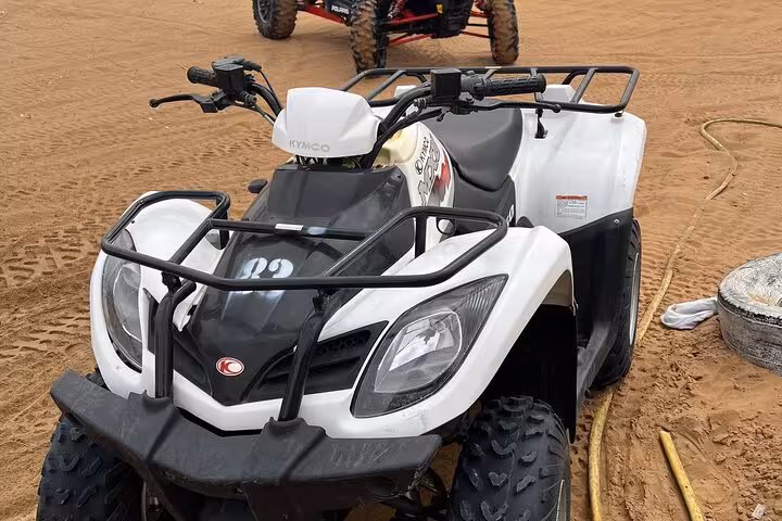 White quad bike ATV on sandy desert track, perfect for self-drive dune bashing and off-road adventure tour