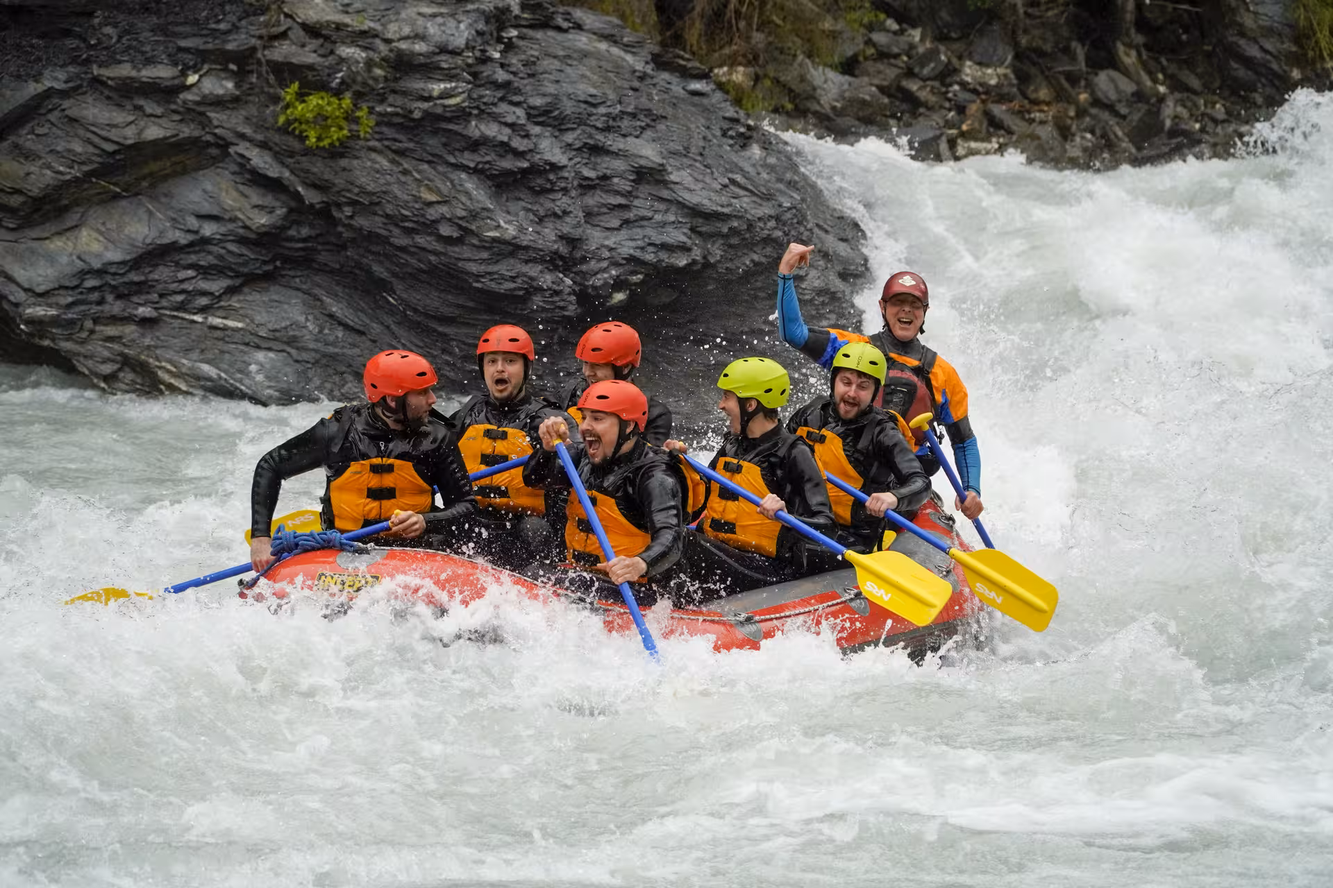 Thrilled group whitewater rafting through exhilarating rapids in Interlaken, Switzerland, with Rafting Interlaken tour.