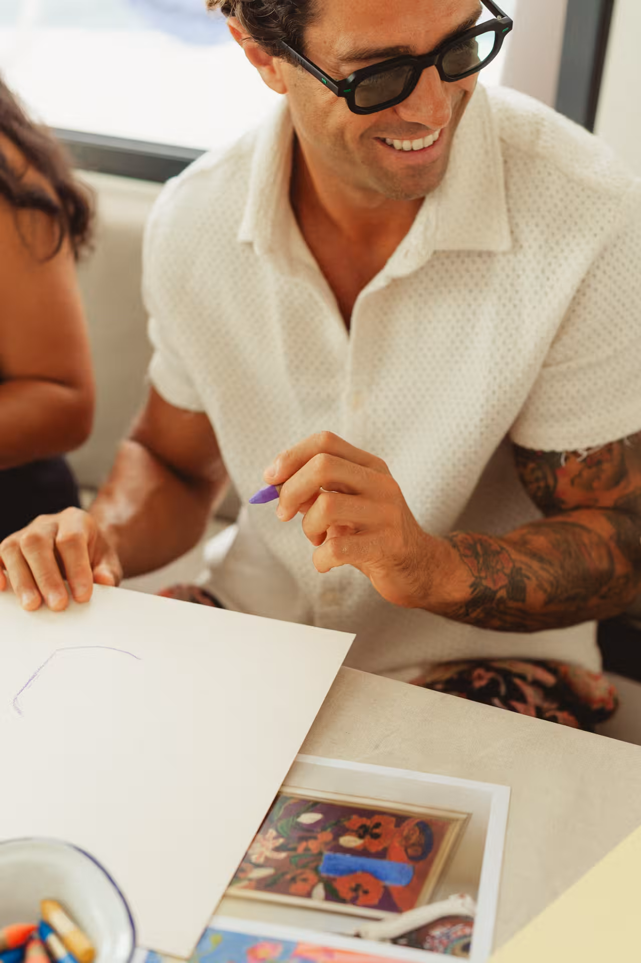 Guest sketching with colored pencil during a Wine & Art paint-and-sip class, relaxed creative vibe