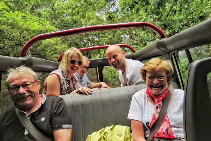 Group enjoying a scenic jeep safari through lush Madeira forests, part of the Wine & Cabo Girão tour experience.