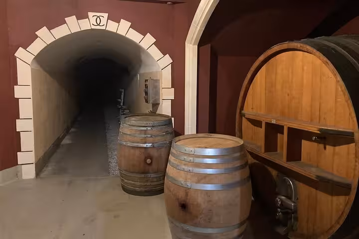 Discover the rustic ambiance of a wine cellar with barrels on the exclusive Cannes and Grasse Private Tour.