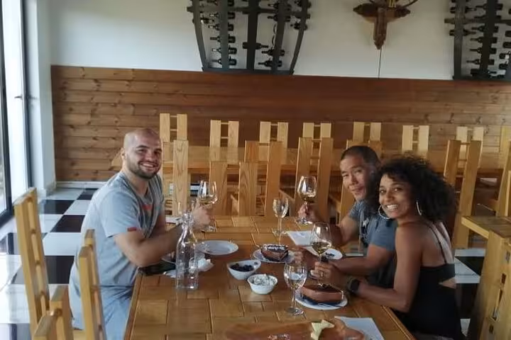 Group enjoying wine tasting in Berat with a spread of local delicacies and wine glasses.