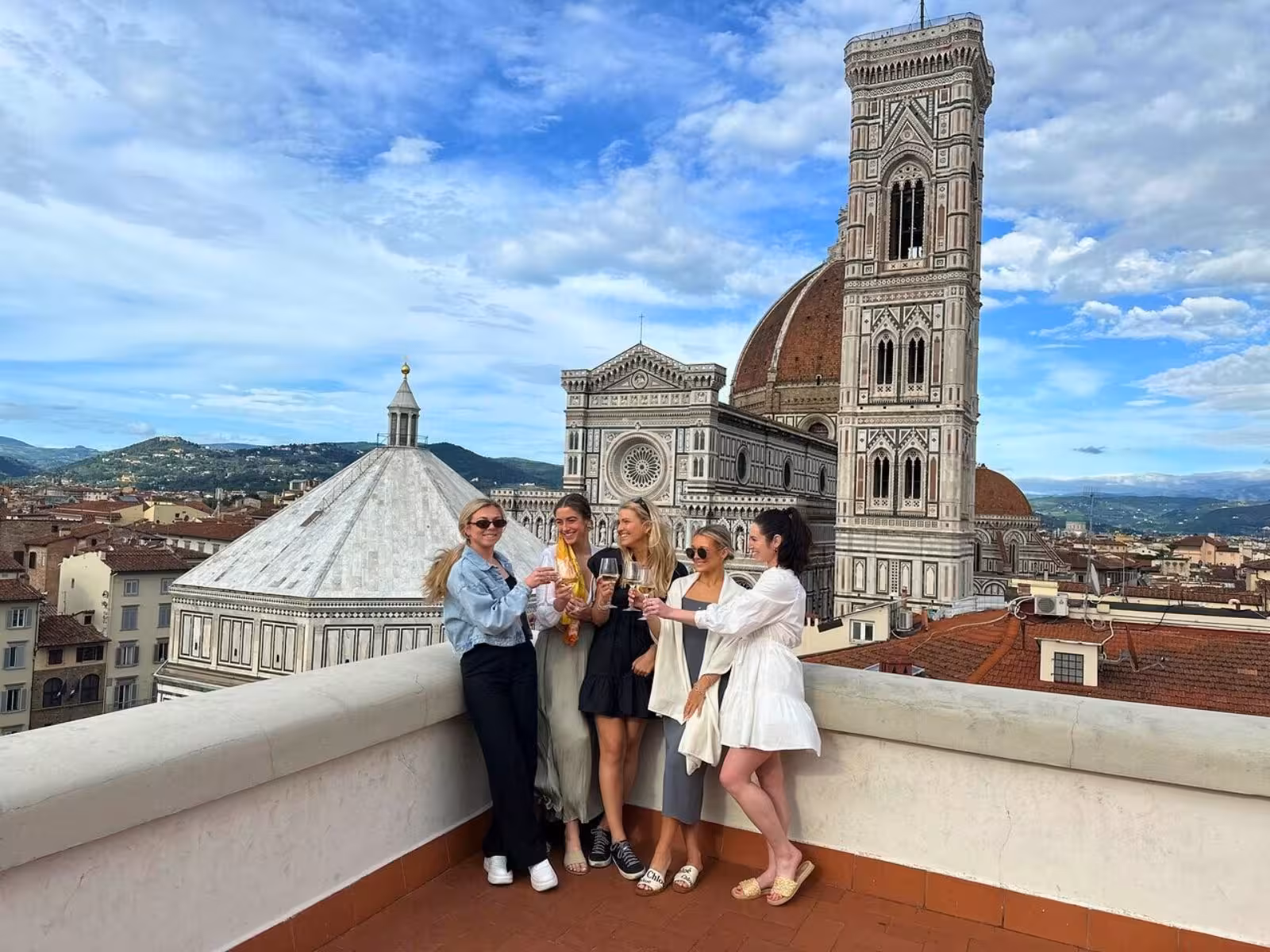 Group enjoying wine tasting with stunning view of Florence's Duomo from exclusive rooftop terrace.