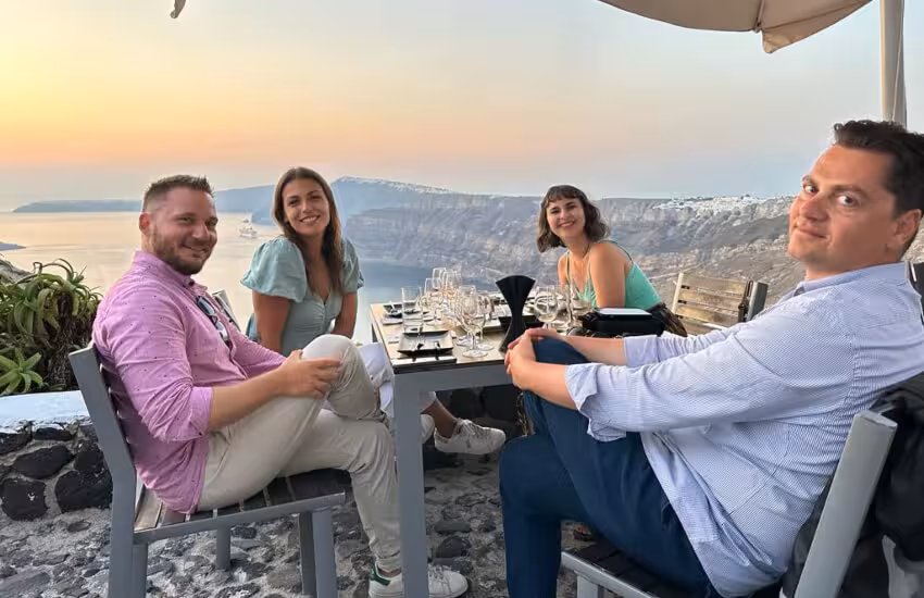 Guests enjoying sunset wine tasting in Santorini with caldera views on a private tour terrace