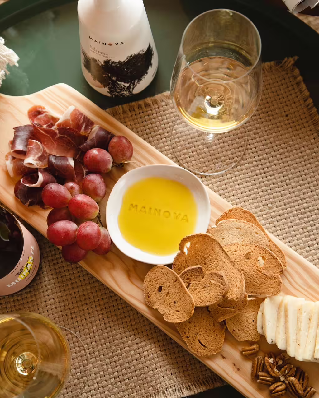 Wine tasting tour setup featuring a selection of three wines, charcuterie, cheese, grapes, and freshly baked bread on a wooden board.