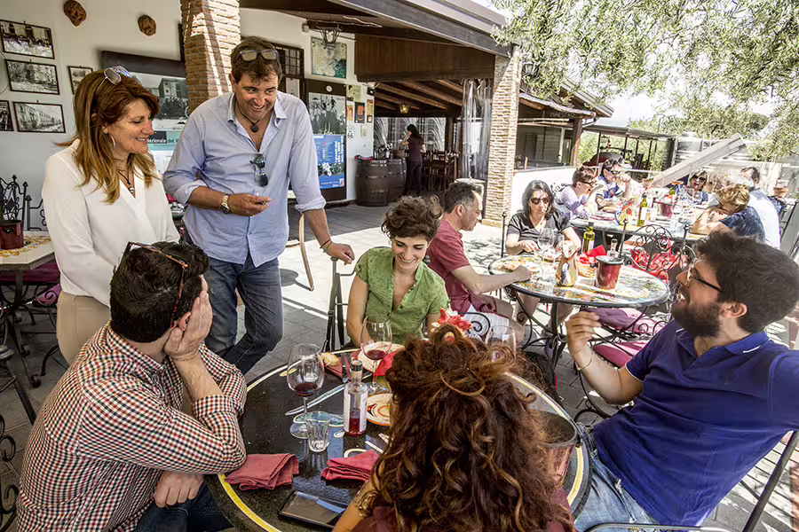 Group wine tasting at a Vesuvius winery terrace near Naples, guests sampling Lacryma Christi wines