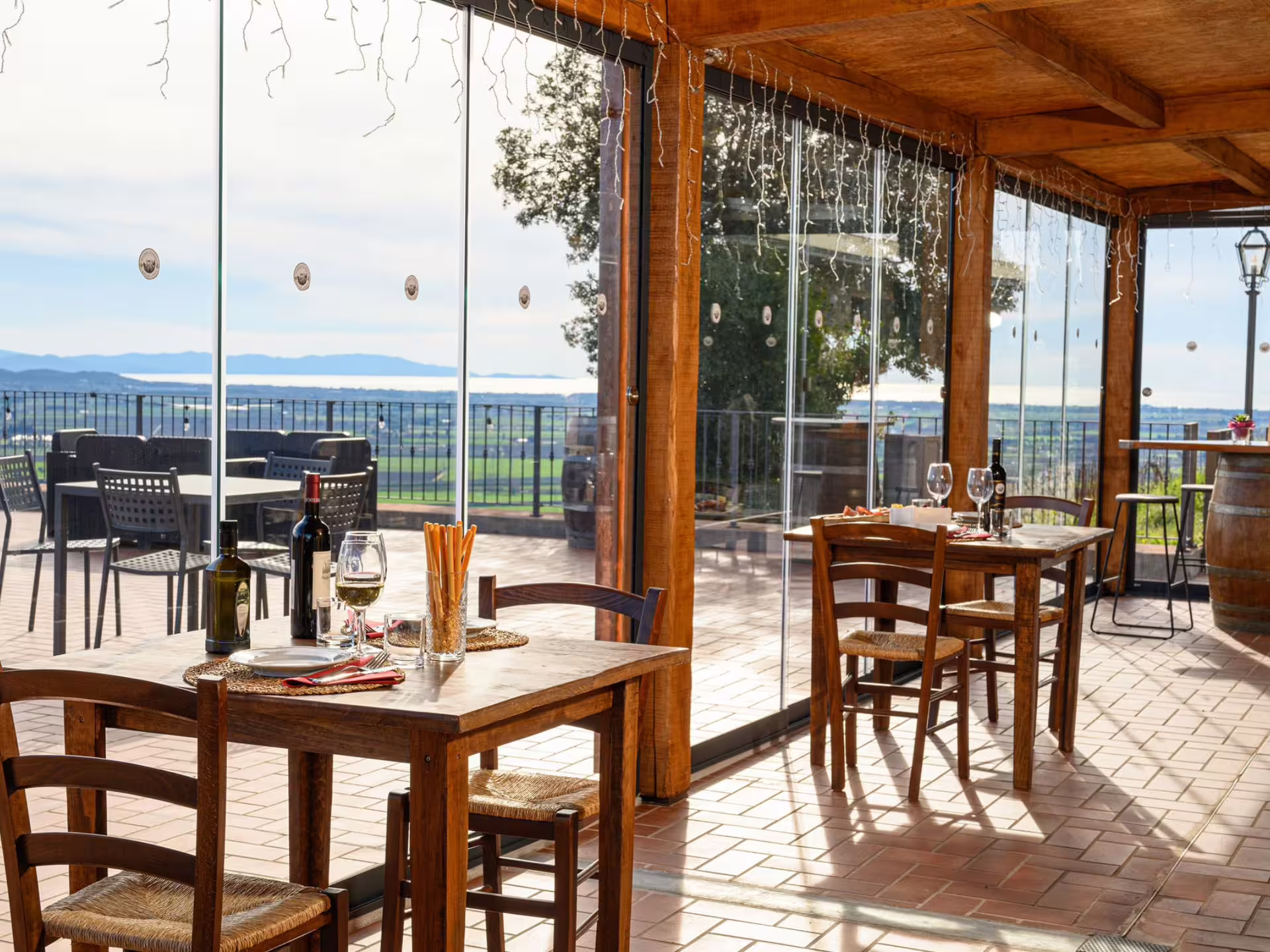 Scenic vineyard view from a rustic dining area with wine and appetizers near Livorno, ideal for wine tasting tours.