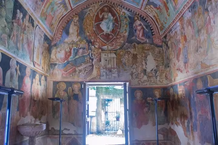 Intricate frescoes adorn the chapel interior on the Wine Tour South of Rome, showcasing rich history and art.