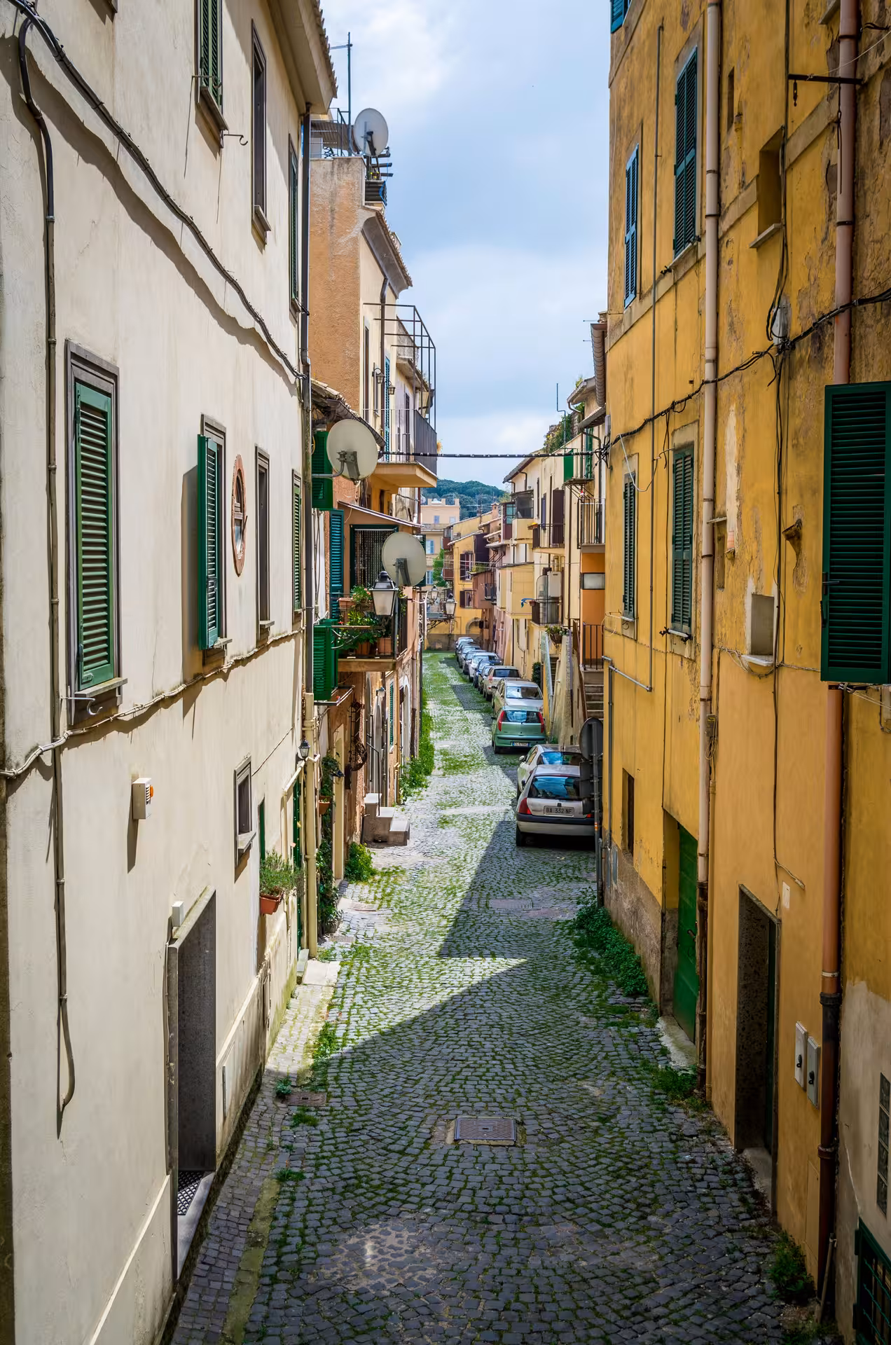 Charming cobblestone street lined with colorful buildings in a quaint town south of Rome.