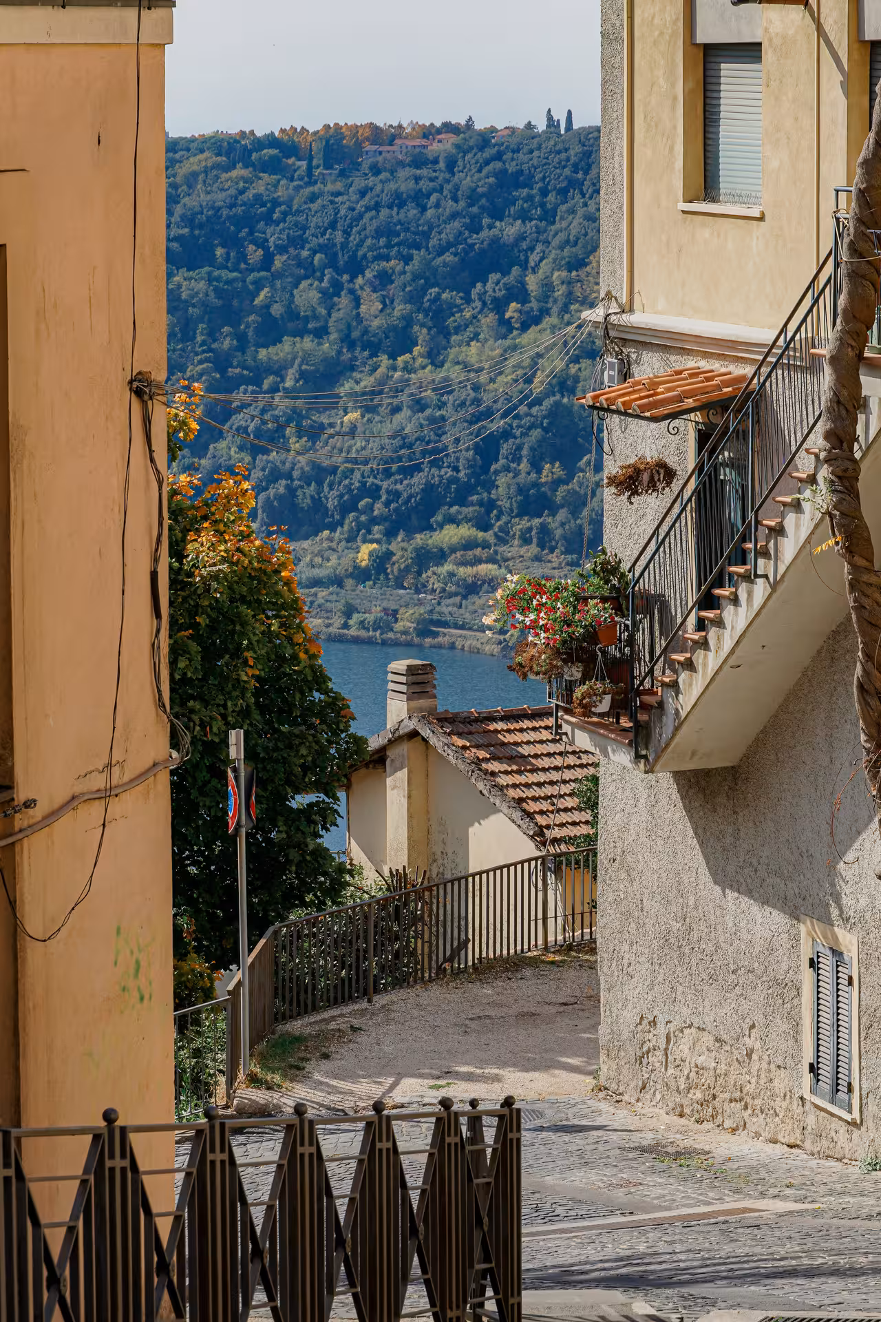 Scenic view of a charming Italian village near Rome with lush green hills and a serene lake in the background.