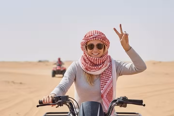 Woman on quad bike in Hurghada desert wearing keffiyeh, enjoying 3-hour ATV safari morning or sunset tour