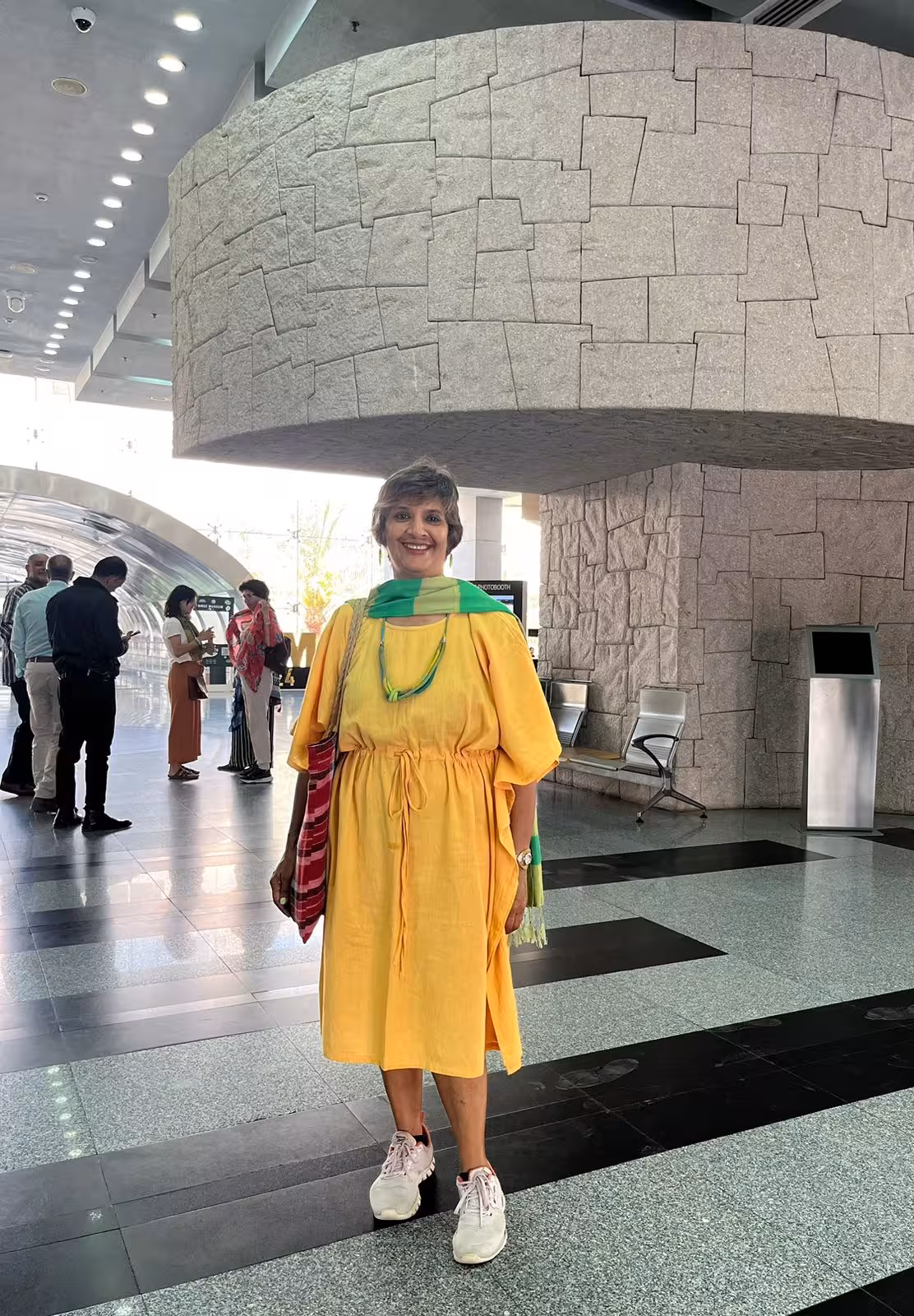 Smiling woman in a yellow dress at a modern Cairo venue, a starting point for the Egypt Golden 15 days tour.