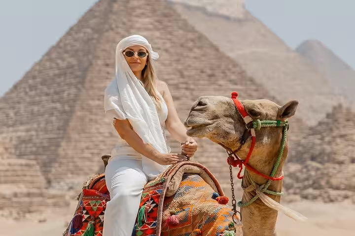 Woman on decorated camel at Giza Pyramids, private pyramids and Sphinx tour with camel ride photo stop
