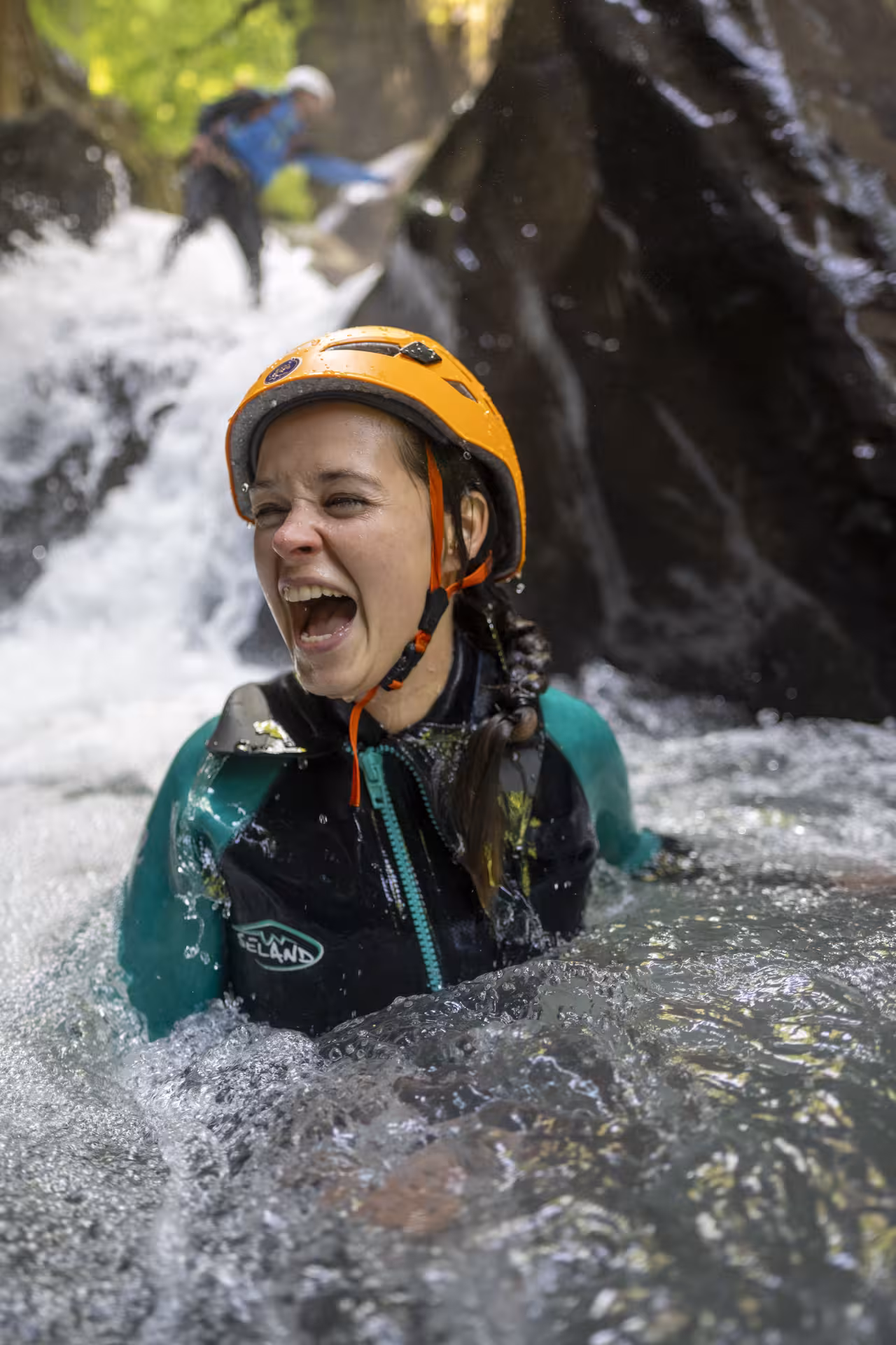 Woman thrills in cascading waters, enjoying the adrenaline-pumping canyoning adventure in Interlaken.
