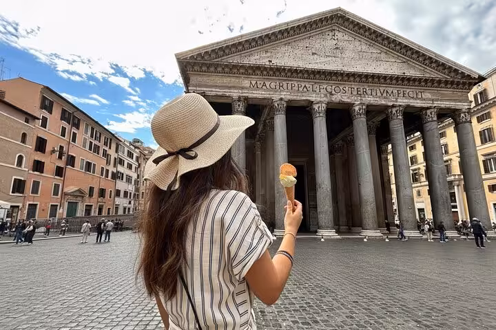 Woman savoring gelato in front of the iconic Pantheon during the Trastevere Food and Wine Tour in Rome.
