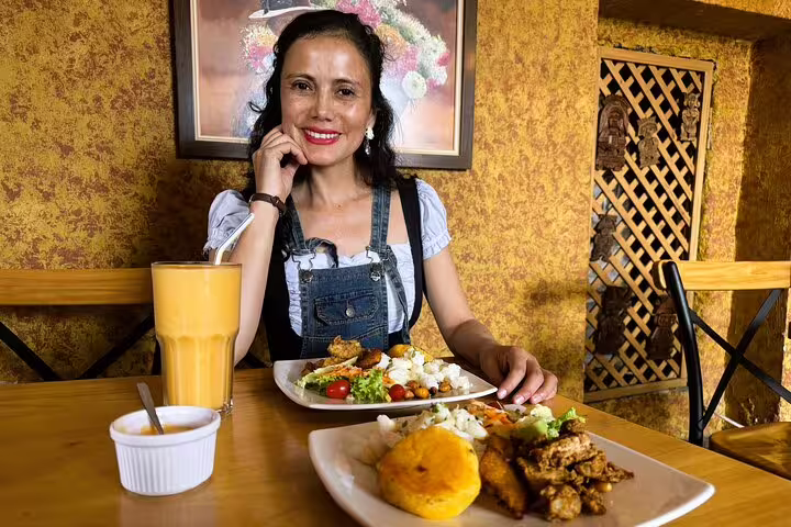 Woman enjoying traditional Ecuadorian cuisine and cacao tasting in a cozy Quito restaurant during a food tour.