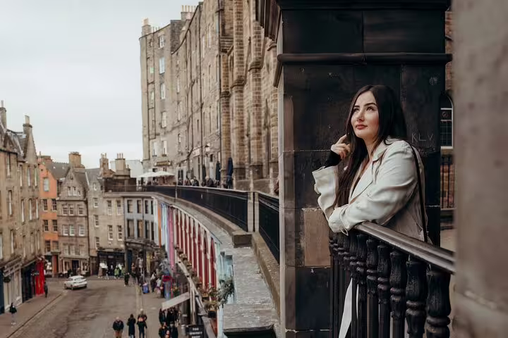 Woman enjoying city views with historic Edinburgh architecture in the background during a private photoshoot.