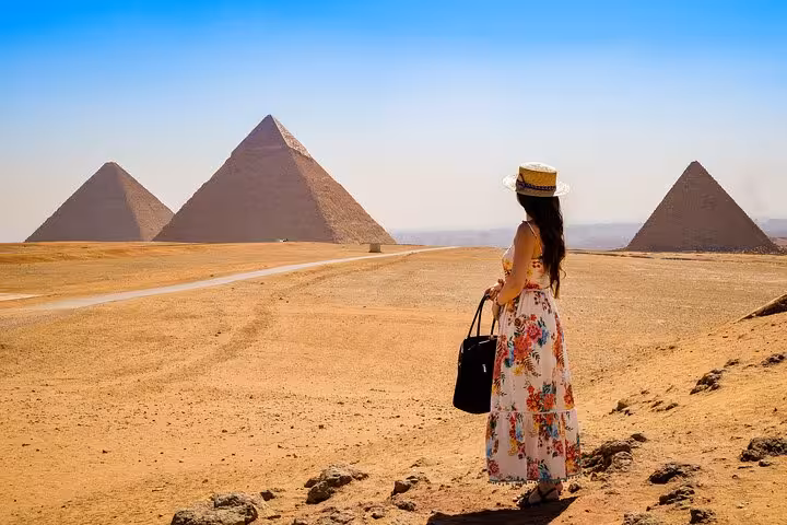 Woman in floral dress facing Giza Pyramids desert view on skip-the-line hidden gems tour, epic photo spot