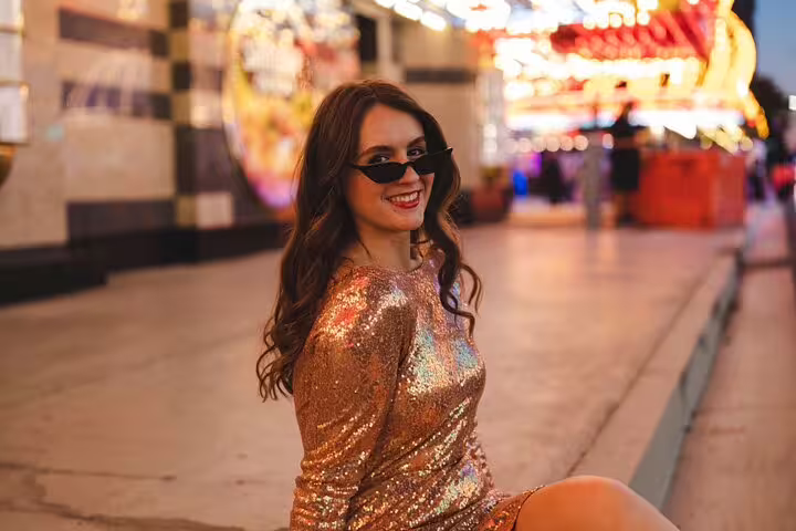 Woman in gold sequin dress posing on Fremont Street for a Las Vegas personal travel photographer photo shoot