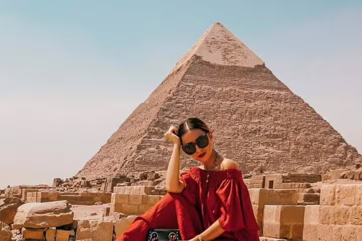 Woman posing by the Great Pyramid of Giza, iconic moment on a Cairo 3-day highlights tour