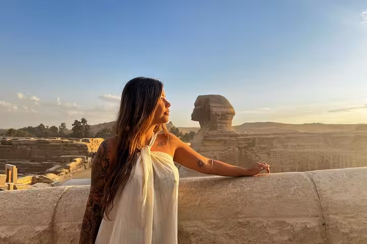 Woman posing by the Great Sphinx at sunrise on a skip-the-line Giza Pyramids hidden gems photo tour