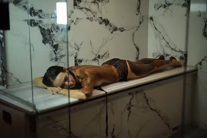 Woman relaxing on marble hammam table with exfoliating scrub, part of 2-hour Luxor spa with massage