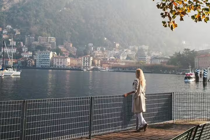 Woman overlooking Lake Como promenade and waterfront town, candid shot from private personal travel photographer tour