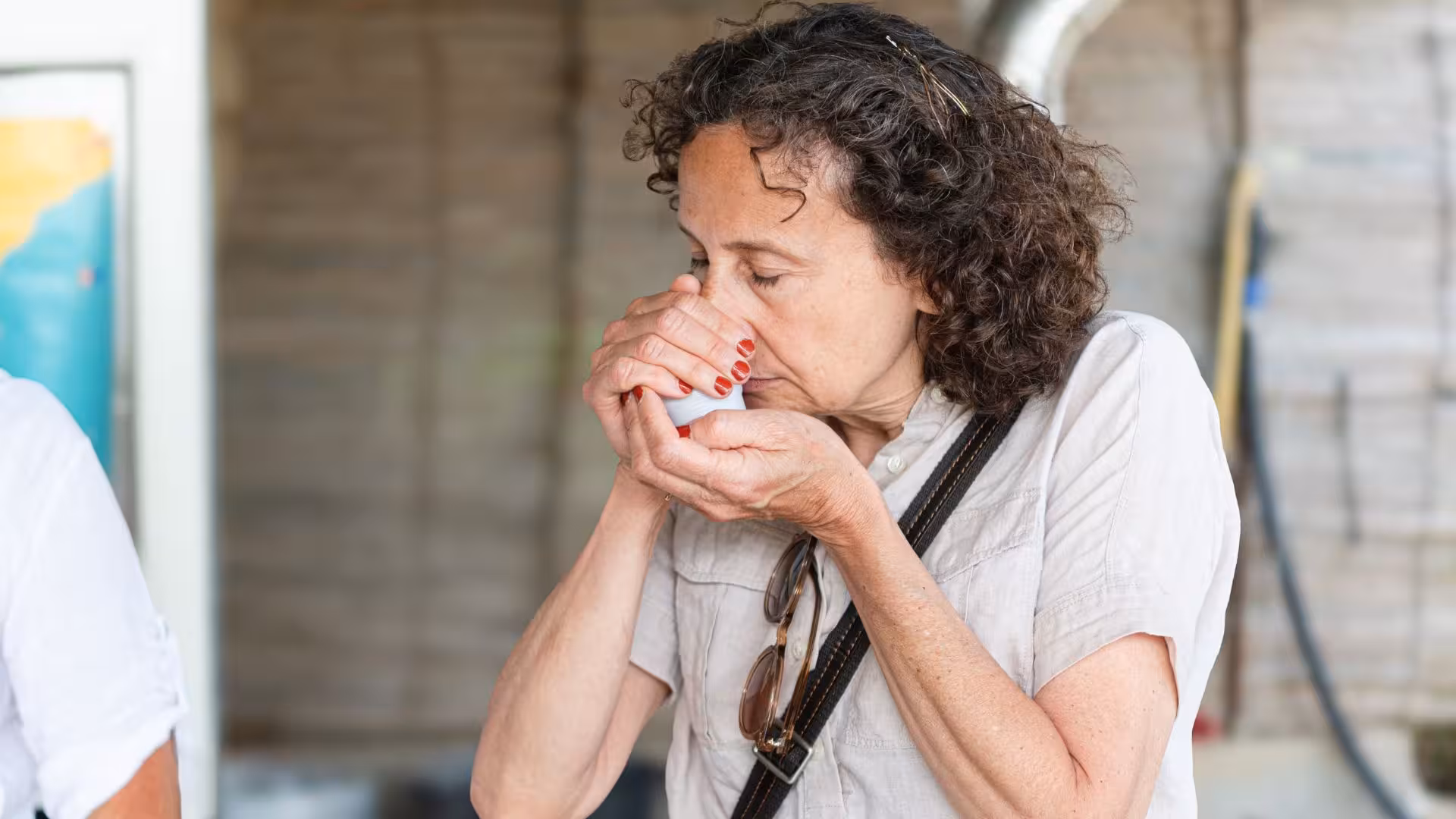 Woman savoring aroma during olive oil tasting at Lotzorai oil mill tour in Tortolì.