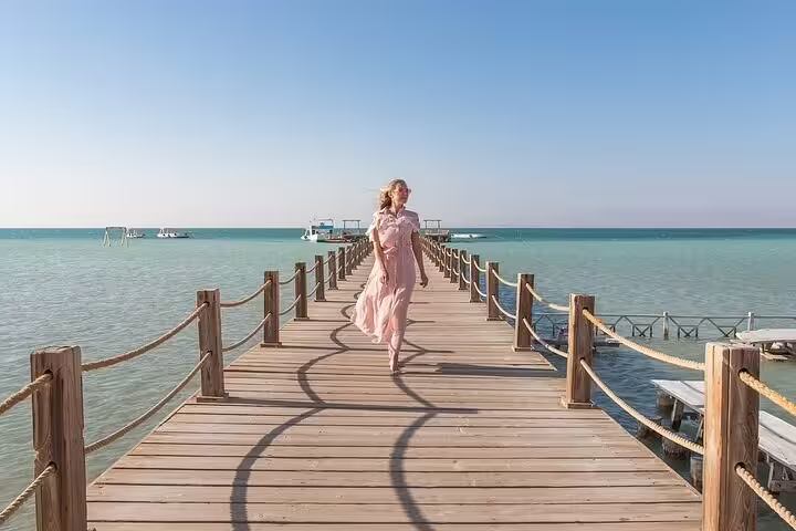 Woman walking on Orange Bay Island pier, Hurghada VIP boat snorkeling day trip in the Red Sea