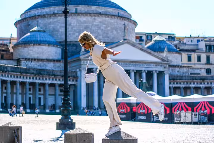 Woman balancing on pedestal in Piazza del Plebiscito, Naples, during a local photographer's photo shoot.
