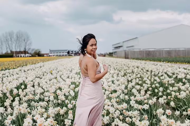 Woman in pink dress in spring flower fields near Amsterdam, photographed on a personal vacation photo tour