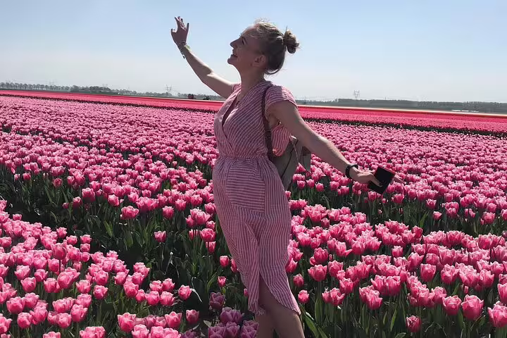 Woman enjoying vast pink tulip fields on Your Own Holland electric bike tour, springtime Holland ride