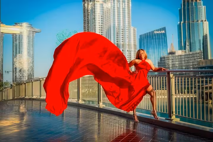 Woman in a flowing red dress poses with Burj Khalifa backdrop, perfect for Instagram videography shoot in Dubai.